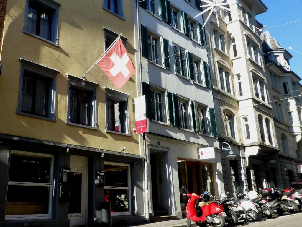 eine Gruppe von Motorrädern, die vor einem Gebäude geparkt sind in der Unterkunft Hotel Weisses Kreuz in St. Gallen