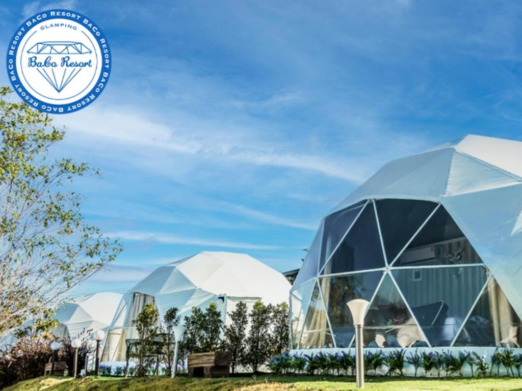 a group of domes in a field with a blue sky at Baco Resort Nagano in Ueda