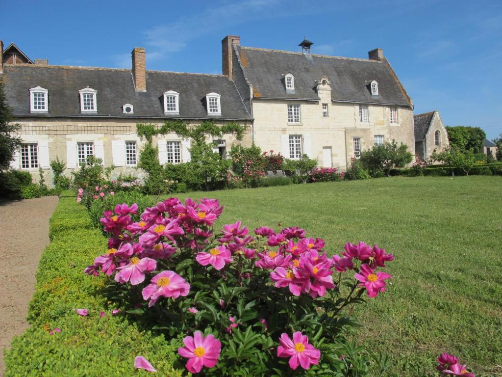 a large house with pink flowers in front of it at Gite du Manoir du Plessis- 3km de Villandry in Savonnières