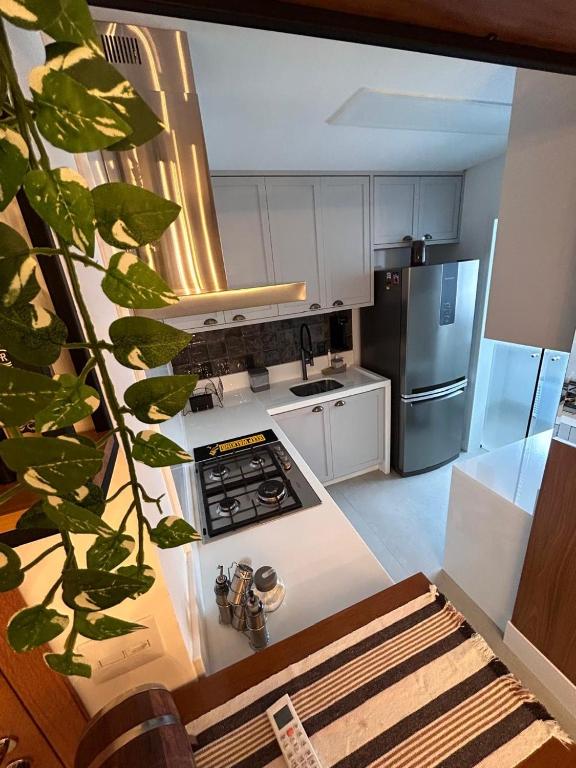 a kitchen with a stove and a stainless steel refrigerator at Apto lindo nas montanhas! in Venda Nova do Imigrante