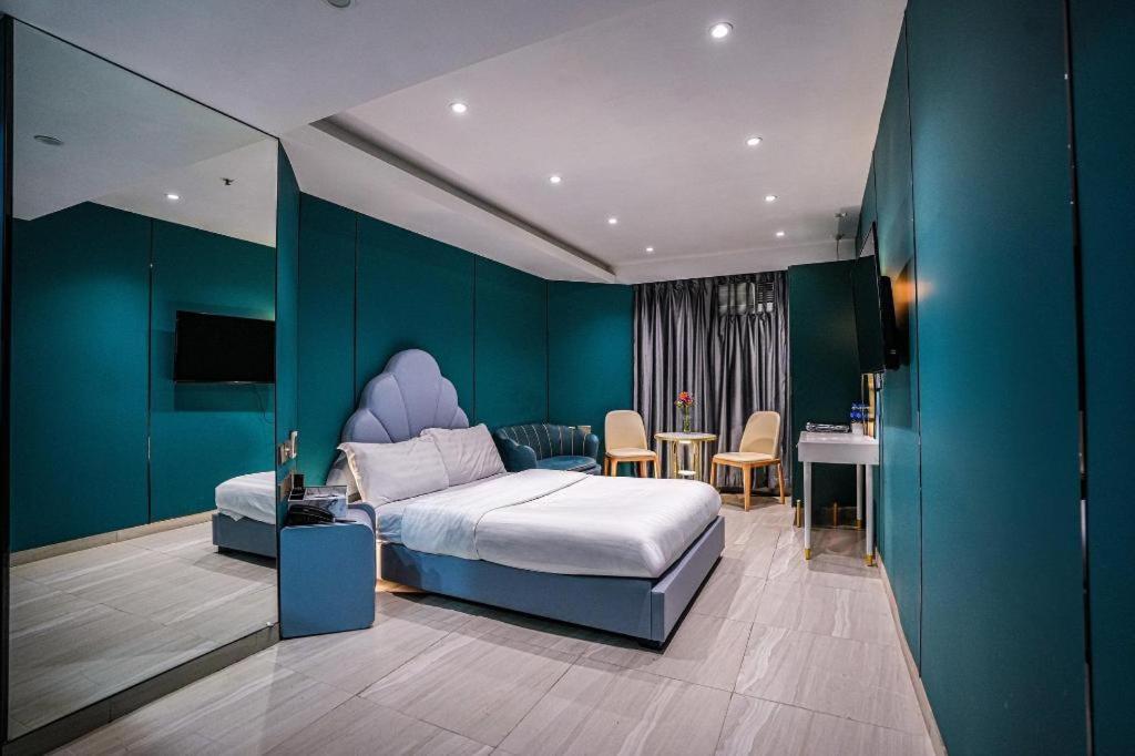 a bedroom with a king sized bed and a table at Sunny Day Hotel in Hong Kong