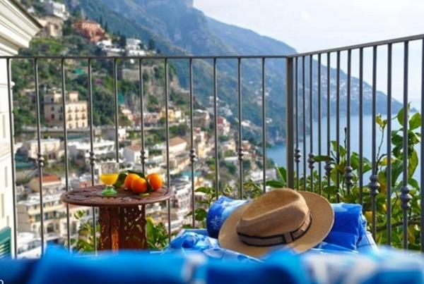 un cappello e frutta su un tavolo sul balcone di Casa Giovanna Positano a Positano