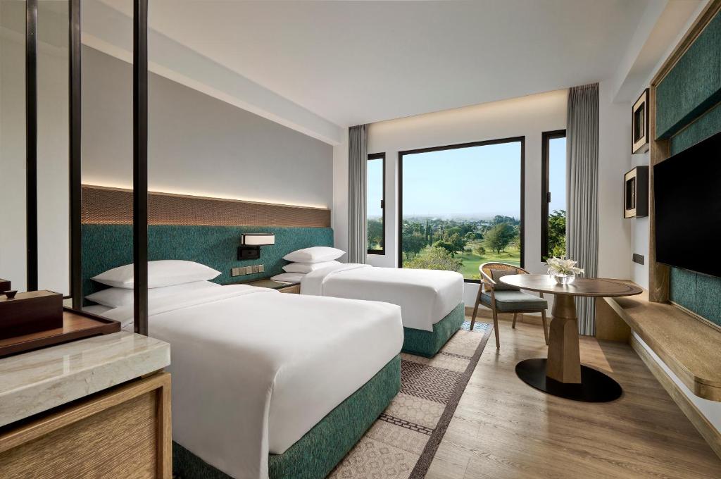 a hotel room with two beds and a television at Hyatt Regency Yogyakarta in Yogyakarta
