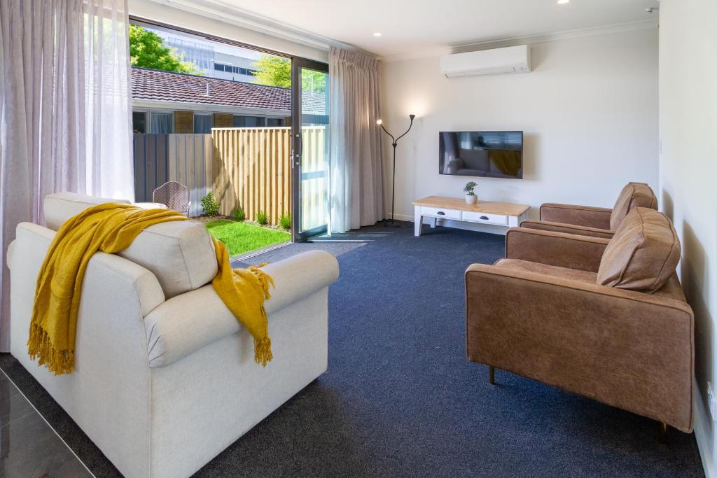 a living room with two couches and a tv at 2BR Townhouse, Riccarton Mall, Hagley Park in Christchurch