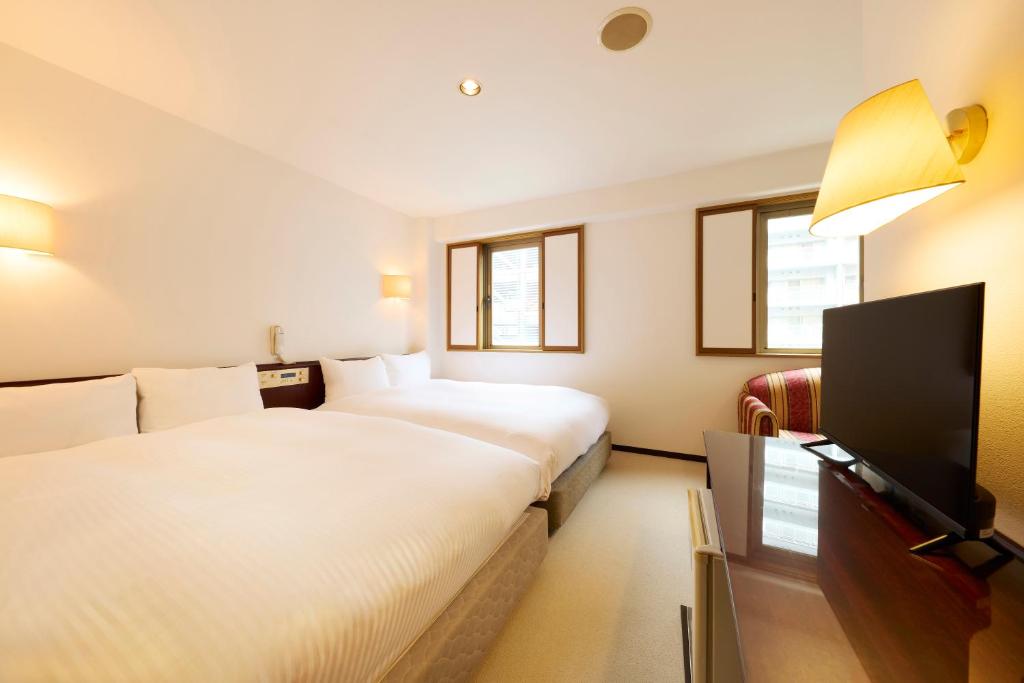 Postel nebo postele na pokoji v ubytování Centurion Hotel Hamamatsu