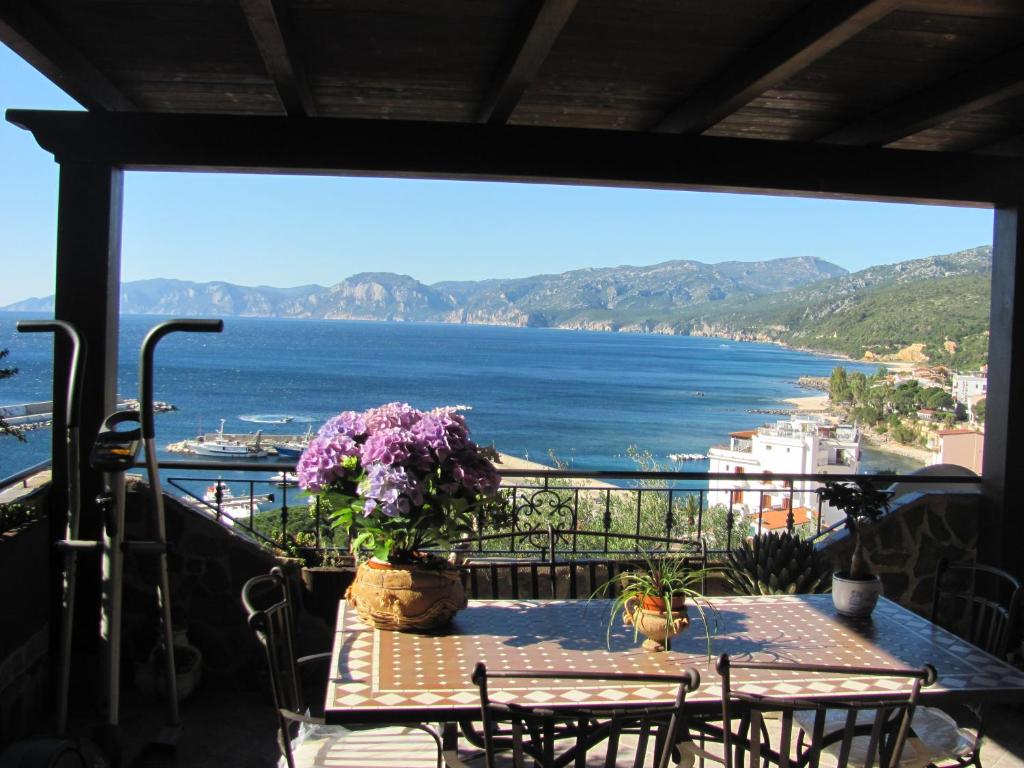 a balcony with a table and a view of the ocean at Appartamento Picasso in Cala Gonone