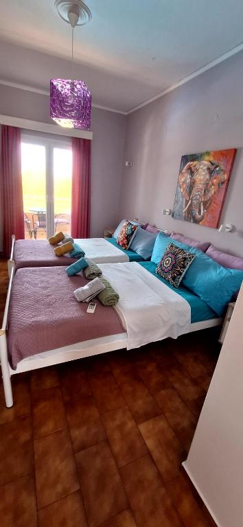 a bedroom with two beds and a painting on the wall at Sausan Hotel in Sidari