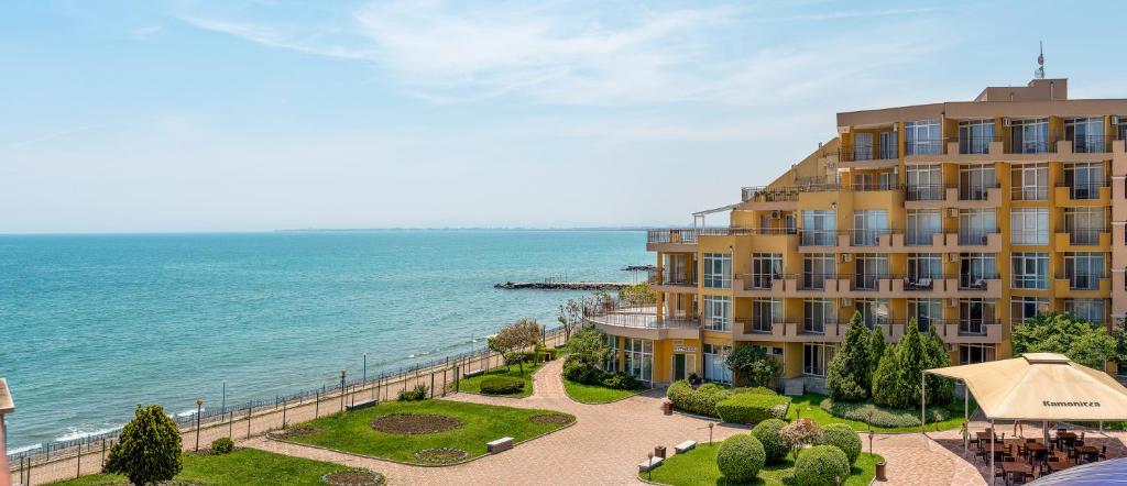 a large yellow building next to the ocean at Midia Holiday Apartments in Aheloy