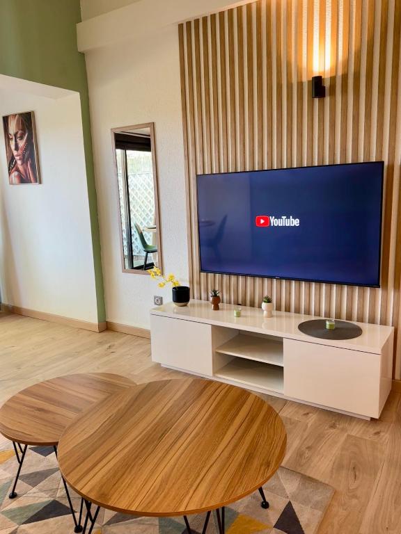 un salon avec une grande télévision et une table dans l'établissement Duplex magnifique pour accueillir jusqu'à 6 personnes, à Arles