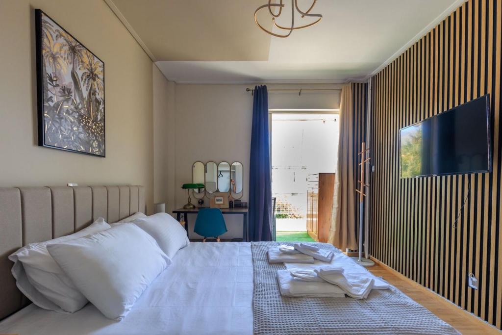 a bedroom with a bed with two towels on it at AIOLOS elegant escapes GLYFADA apartment in Athens