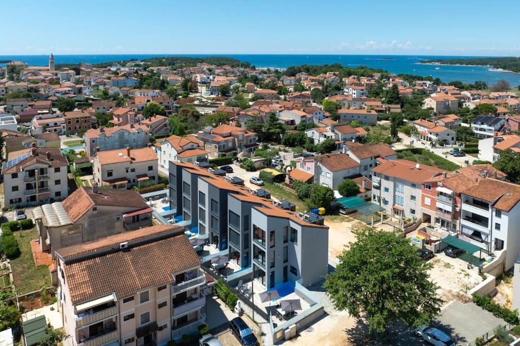 an aerial view of a city with houses and the ocean at Casa Cocooon in Funtana
