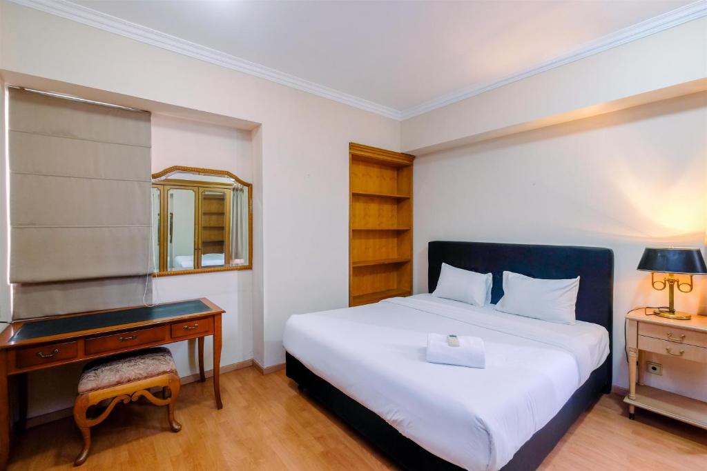 a bedroom with a bed and a desk and a bed at Luxury 3BR Apartment at Sudirman Tower Condominium By Travelio in Jakarta