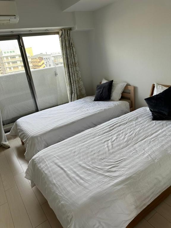 Postel nebo postele na pokoji v ubytování Residence天王寺東