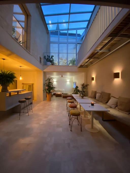 Cette grande chambre dispose d'un canapé, de tables et de chaises. dans l'établissement La Maison Naturospa, à Chaumont