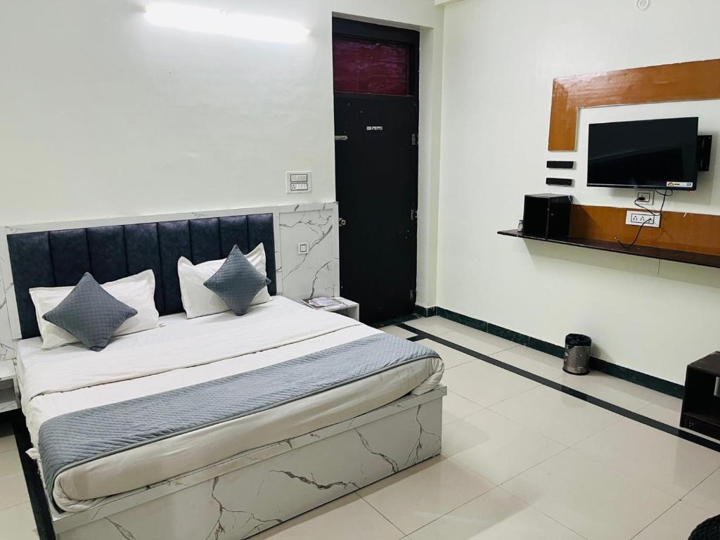 a bedroom with a bed and a flat screen tv at New Hotel Blue Moon in Jaipur