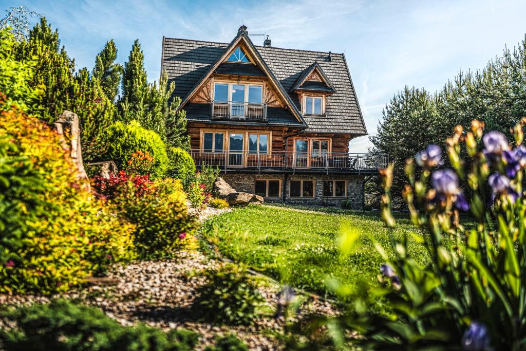a large house with a garden in front of it at VisitZakopane - Willa Karina in Witów