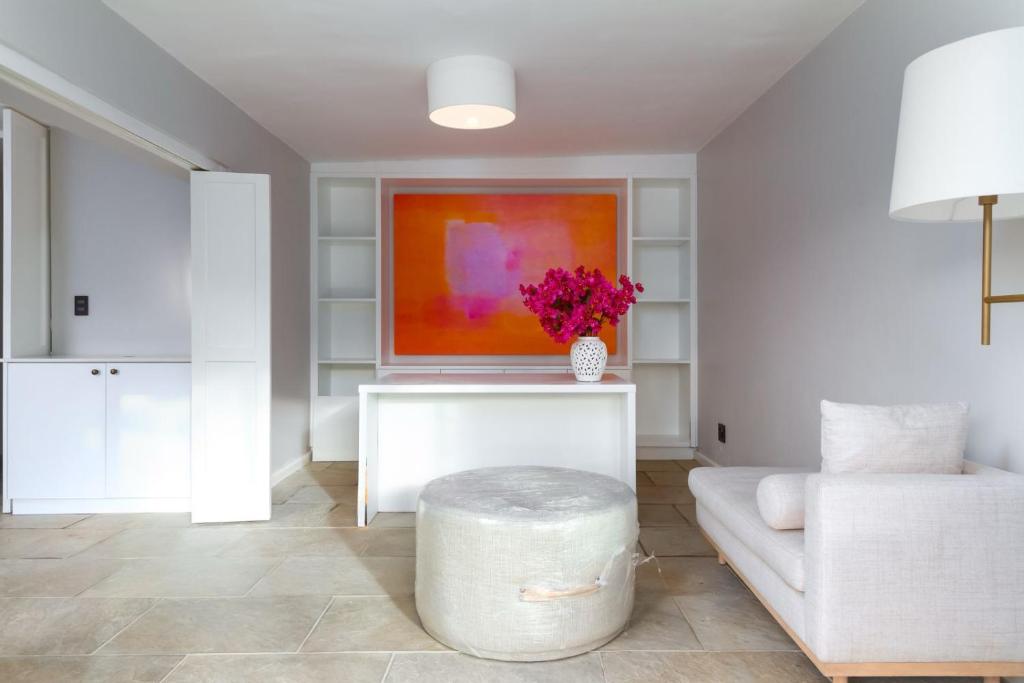 a living room with a couch and a vase of flowers at Bay Haven Collection in Cape Town