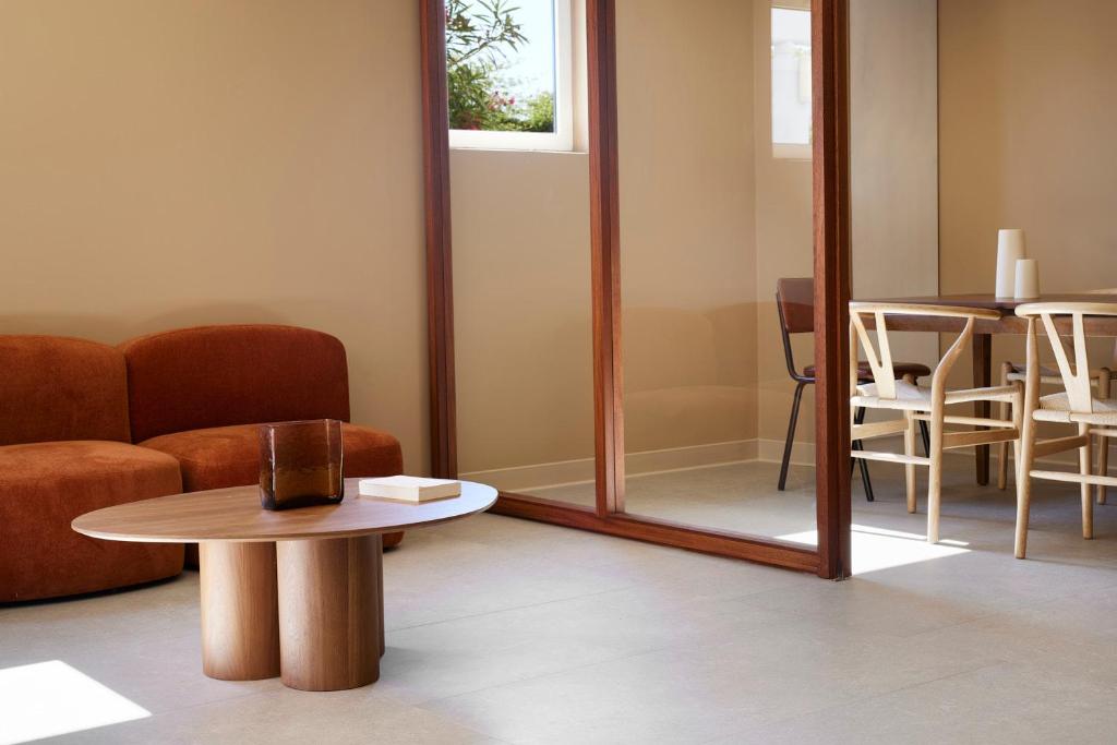 a living room with a mirror and a table at Hotel des Victoires - Restaurant in Cannes