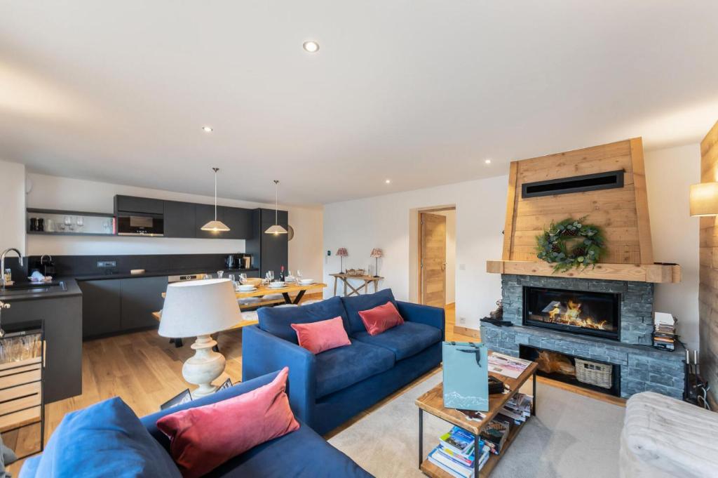 un salon avec un canapé bleu et une cheminée dans l'établissement Les Chalets Du Cheval Noir - Construction neuve proche de toutes les commodités MAE-6441, à Saint-Martin-de-Belleville