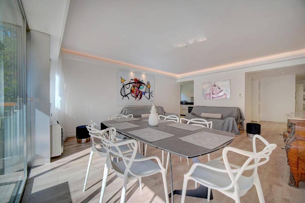 une salle à manger avec une table et des chaises blanches dans l'établissement REF 1425 - Cannes Center - Apartment for rent, à Cannes