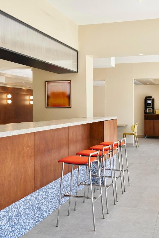 a row of orange stools at a bar at Hotel des Victoires - Restaurant in Cannes