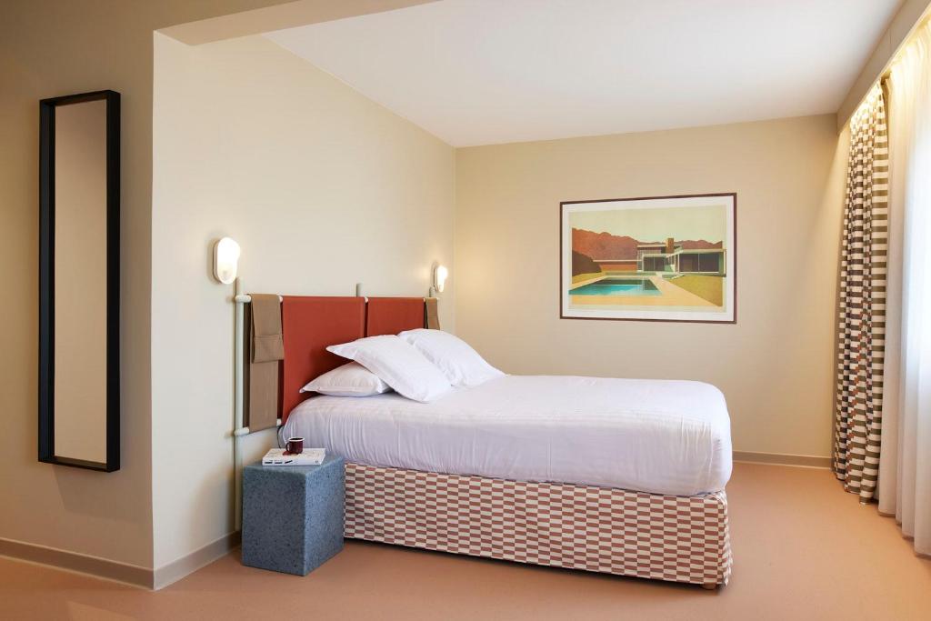 a hotel room with a bed and a pool at Hotel des Victoires - Restaurant in Cannes