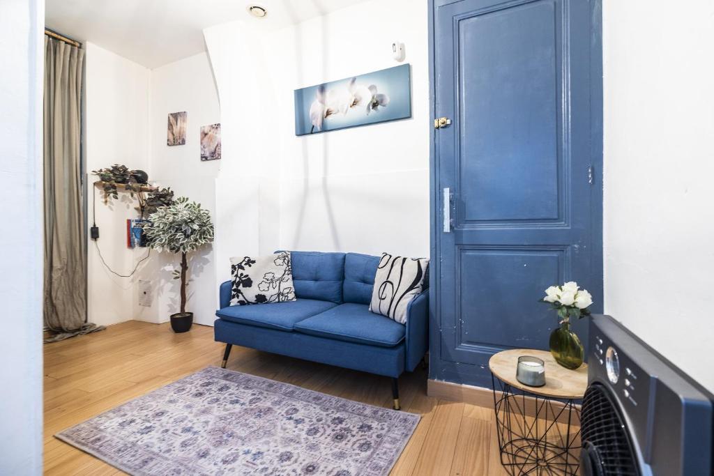 - un canapé bleu dans le salon avec une porte bleue dans l'établissement Comédie 2 - Appt en plein centre de Perpignan, à Perpignan