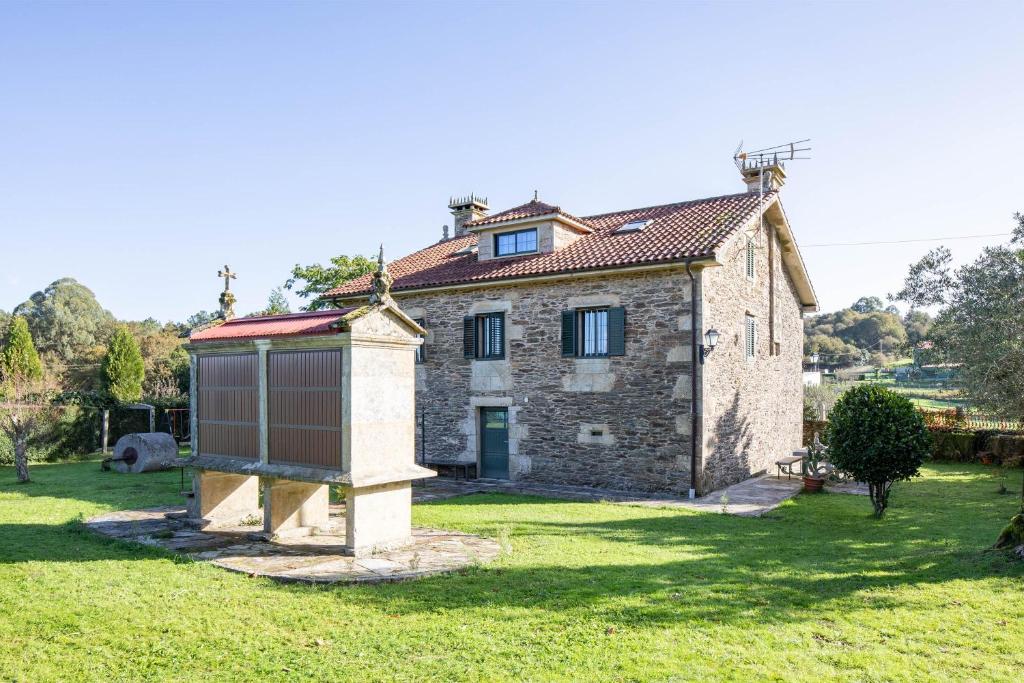 an old stone house with a bird feeder in front of it at Casa Da Puza in Forcarei
