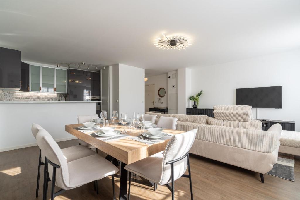 a dining room with a table and chairs and a couch at Apart' MIN - Disneyland Paris - 3 Bedrooms - 2 Parking Spots in Bailly-Romainvilliers