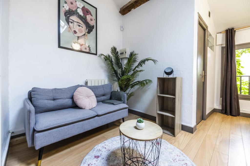 un salon avec un canapé bleu et une table dans l'établissement Comédie 3 - Appt centre historique de Perpignan, à Perpignan
