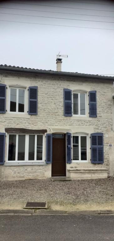 une maison en briques avec des volets bleus et une porte dans l'établissement Charmant duplex des tilleuls, à Demange-aux-Eaux