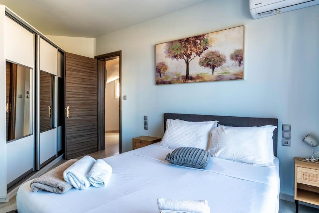 sypialnia z dużym białym łóżkiem z 2 poduszkami w obiekcie Zefyros Suite , Seafront retreat ! w mieście Panormos