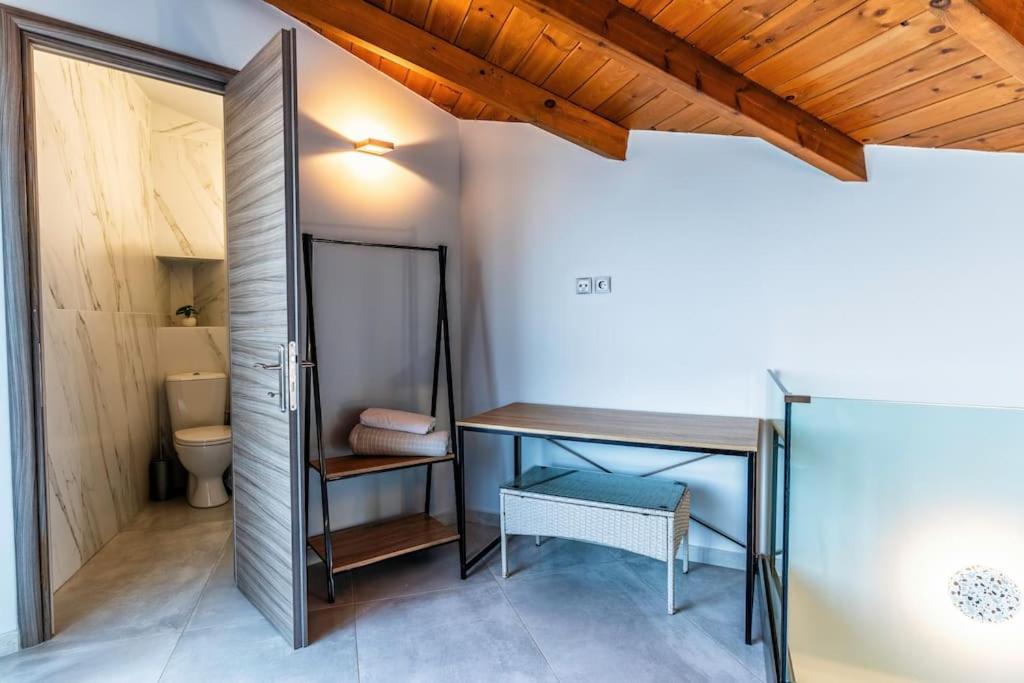łazienka z biurkiem i toaletą w obiekcie Zefyros Suite , Seafront retreat ! w mieście Panormos
