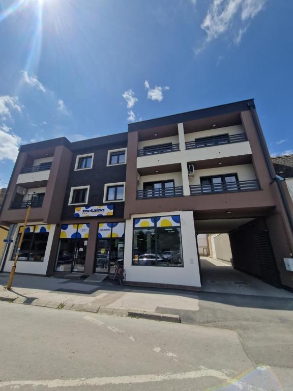 un grande edificio con un negozio in una strada di Liberte Apartments a Sombor