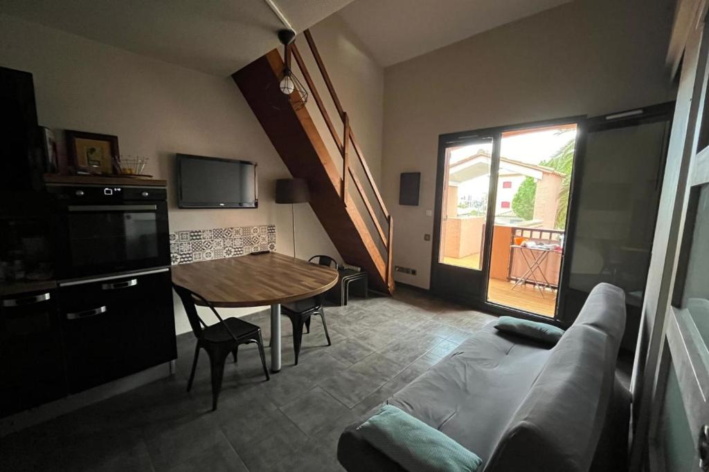 un salon avec une table et un canapé dans l'établissement Cosy flat with pool and sea view, à Saint-Cyprien