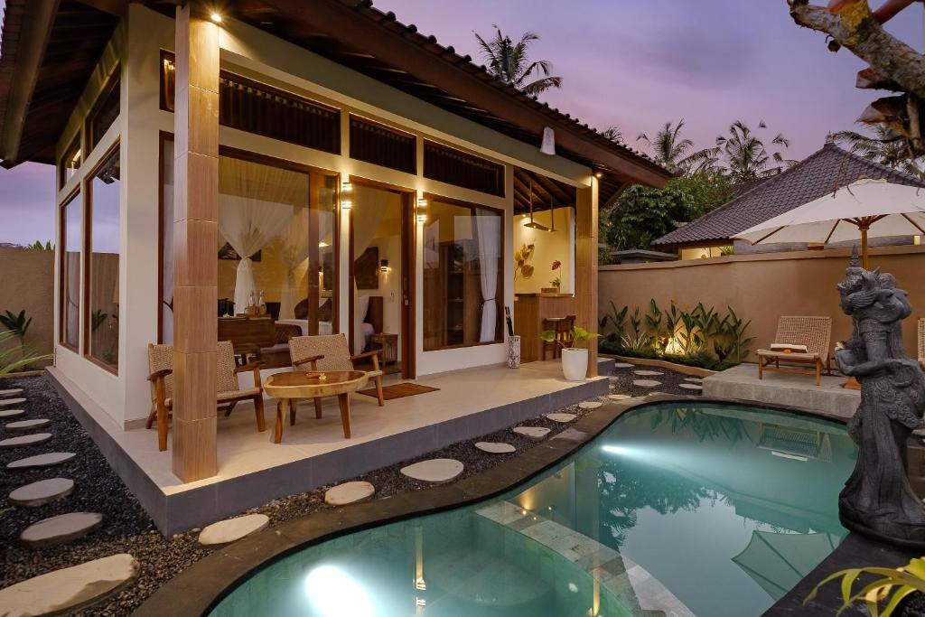 a villa with a swimming pool and a house at Sadhaka Ubud Villa in Ubud
