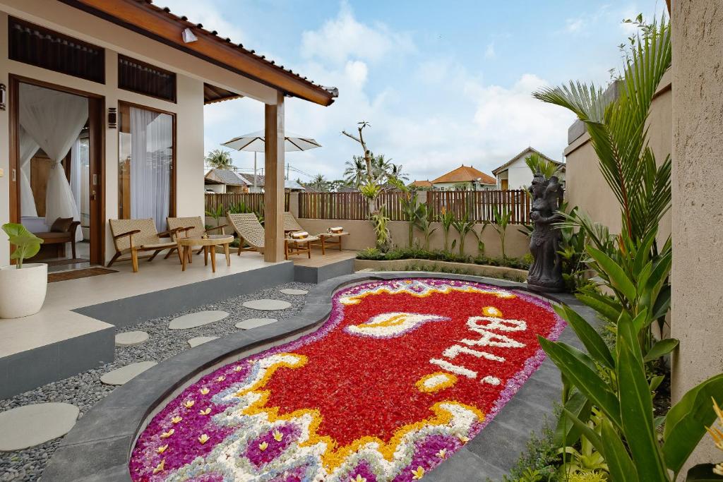 a rug with the word stay painted on it in front of a house at Sadhaka Ubud Villa in Ubud