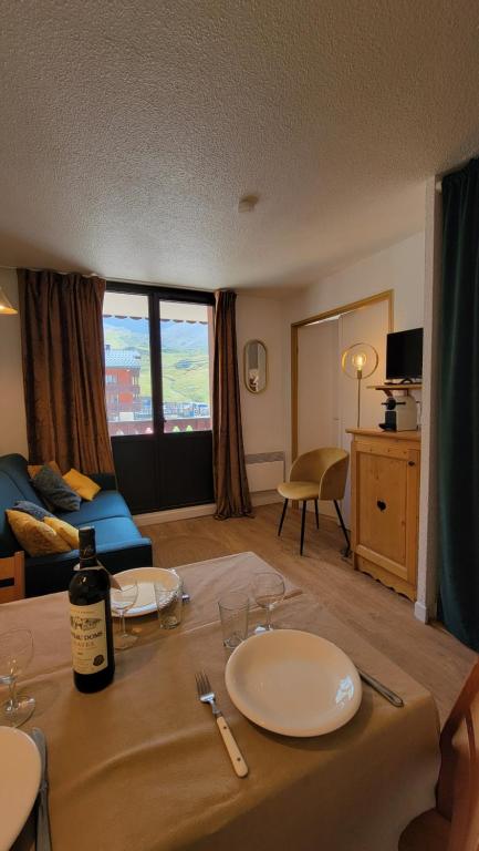 un salon avec une table avec une bouteille de vin dans l'établissement Val Claret-Ski aux pieds, 4 pers, 1 chambre, Balcon Sud, à Tignes