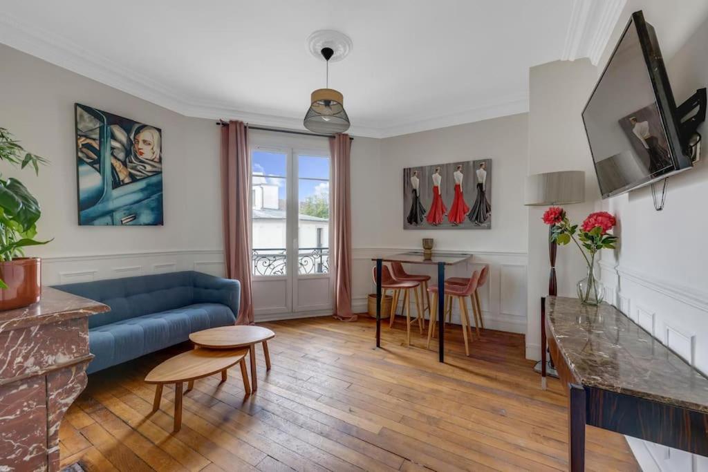 un salon avec un canapé bleu et une table dans l'établissement Parisian Vibe Near Stade de France, 20 min to Champs-Élysées, à Saint-Denis