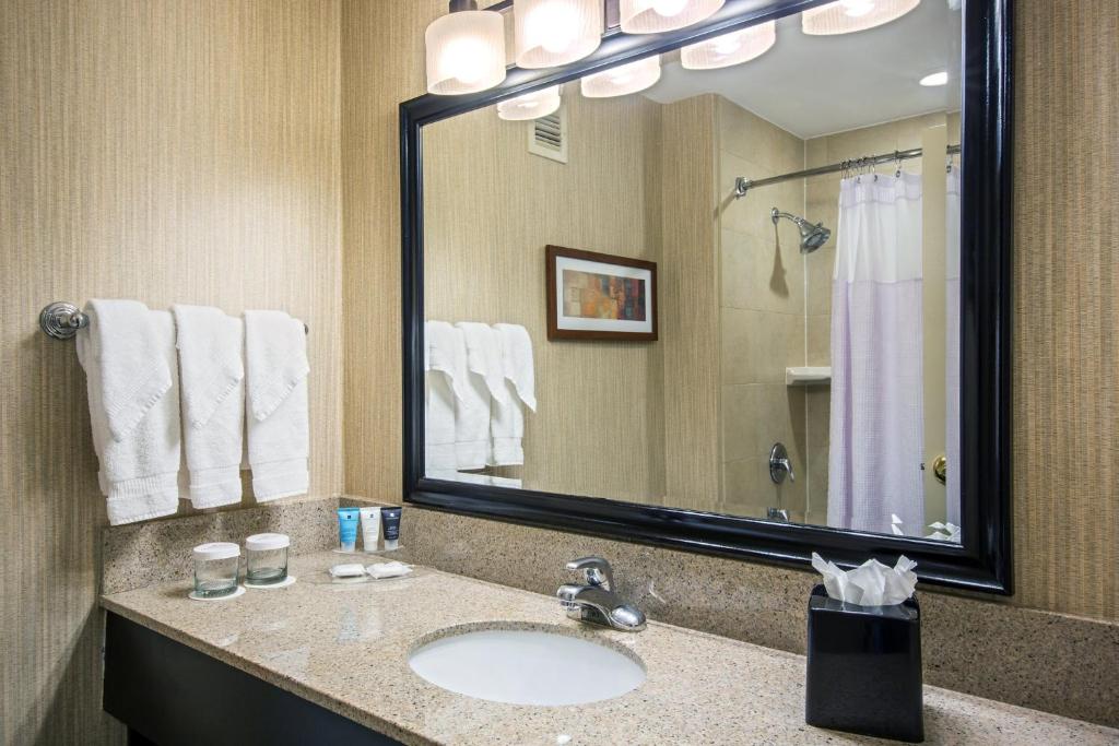 a bathroom with a sink and a large mirror at Crowne Plaza Newark Airport by IHG in Elizabeth