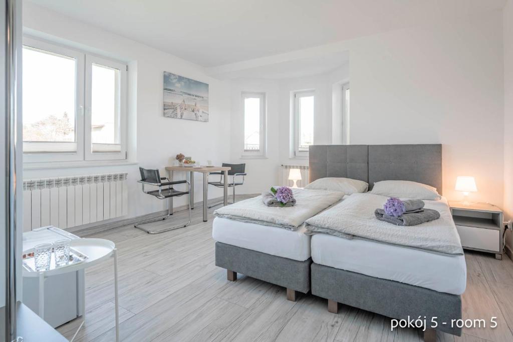 a bedroom with a large bed with purple flowers on it at Remus House Apartments spokojny wypoczynek dla par, tylko pokoje 2-osobowe in Jastrzębia Góra