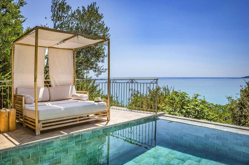 a bed sitting on a deck next to a swimming pool at Villa Kalou Cottage by Villa Plus in Mousata