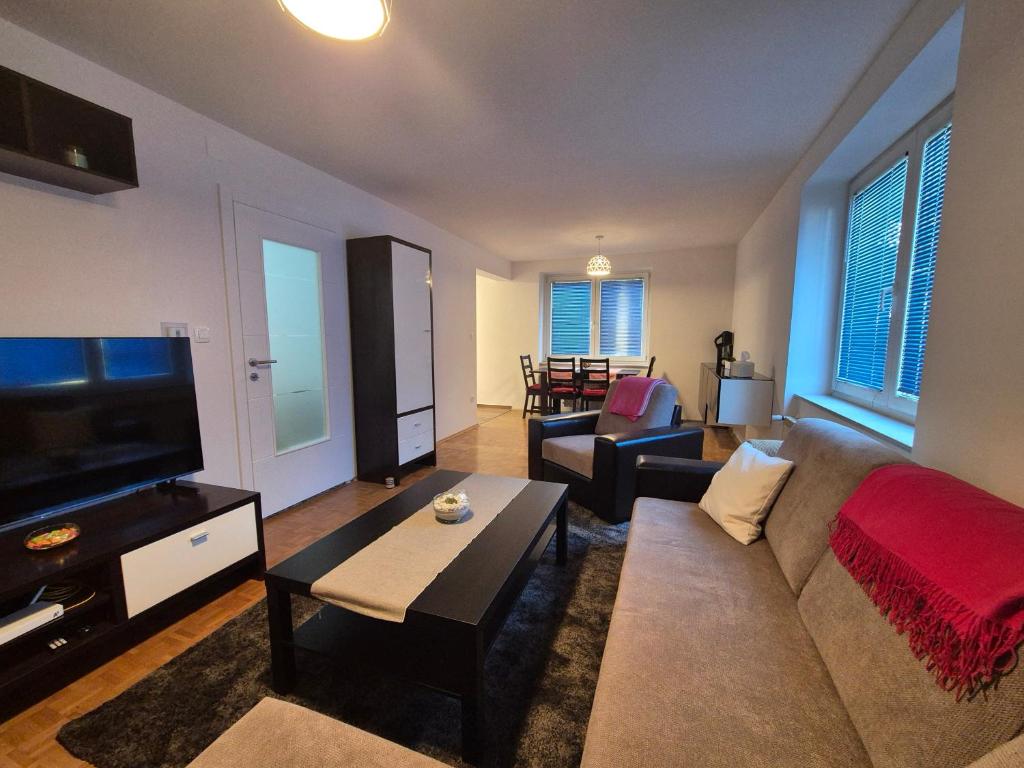 een woonkamer met een bank en een flatscreen-tv bij RingPeace Apartment, Trnsko in Zagreb