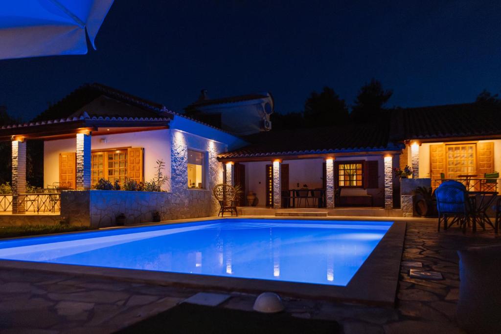 a swimming pool in front of a house at night at Gravanis Resort in Sikáminon