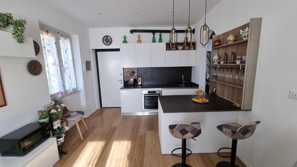 a kitchen with white cabinets and a black counter top at Evergreen House - Japartments in Genova