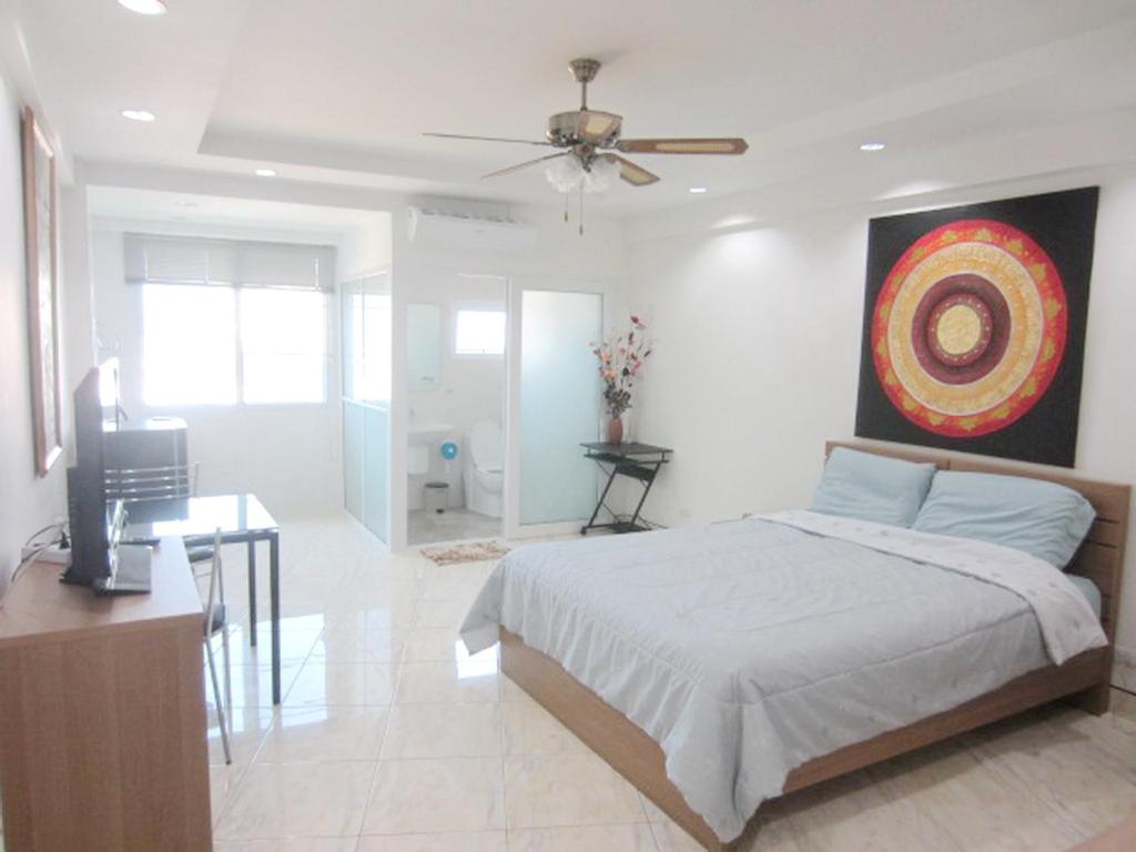 1 dormitorio con 1 cama y una pintura en la pared en DAO Studio Apartments, en Patong Beach