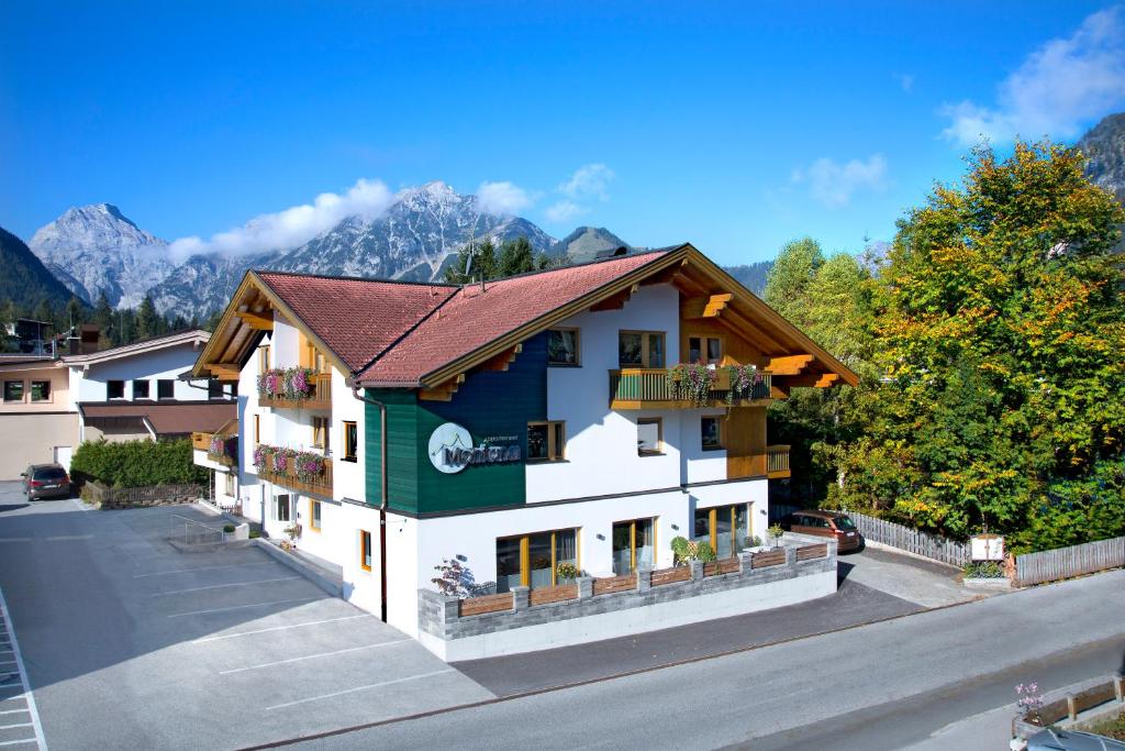 ein Gebäude mit einem Berg im Hintergrund in der Unterkunft Apart Garni Montana in Pertisau