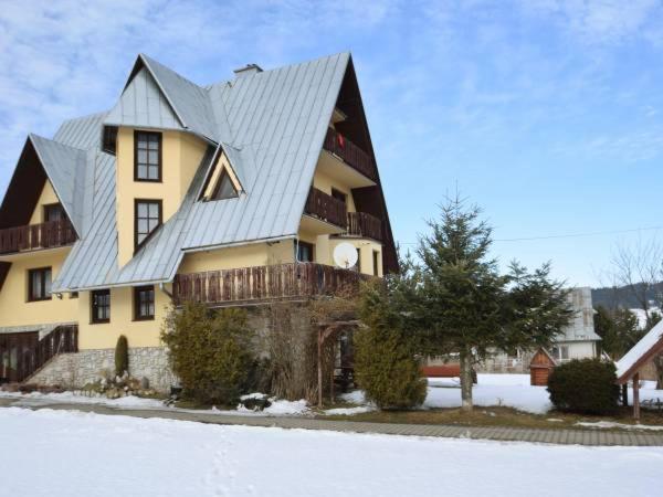 a large yellow house with a metal roof at Lila in Bukowina Tatrzańska