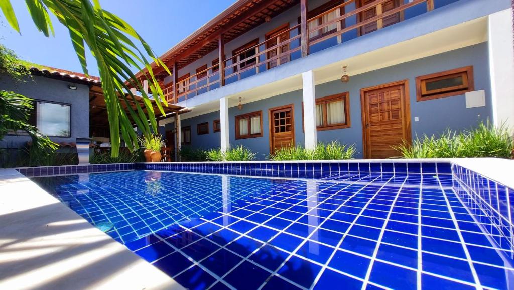 a swimming pool in front of a house at Pousada La Vita in São Miguel dos Milagres