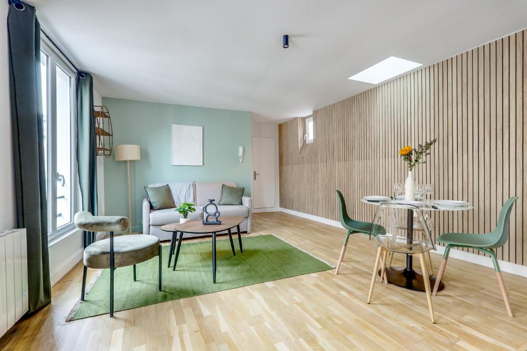 un salon avec une table, des chaises et un canapé dans l'établissement Montmartre l Close to Sacré-Coeur & Rue des Abbesses, à Paris